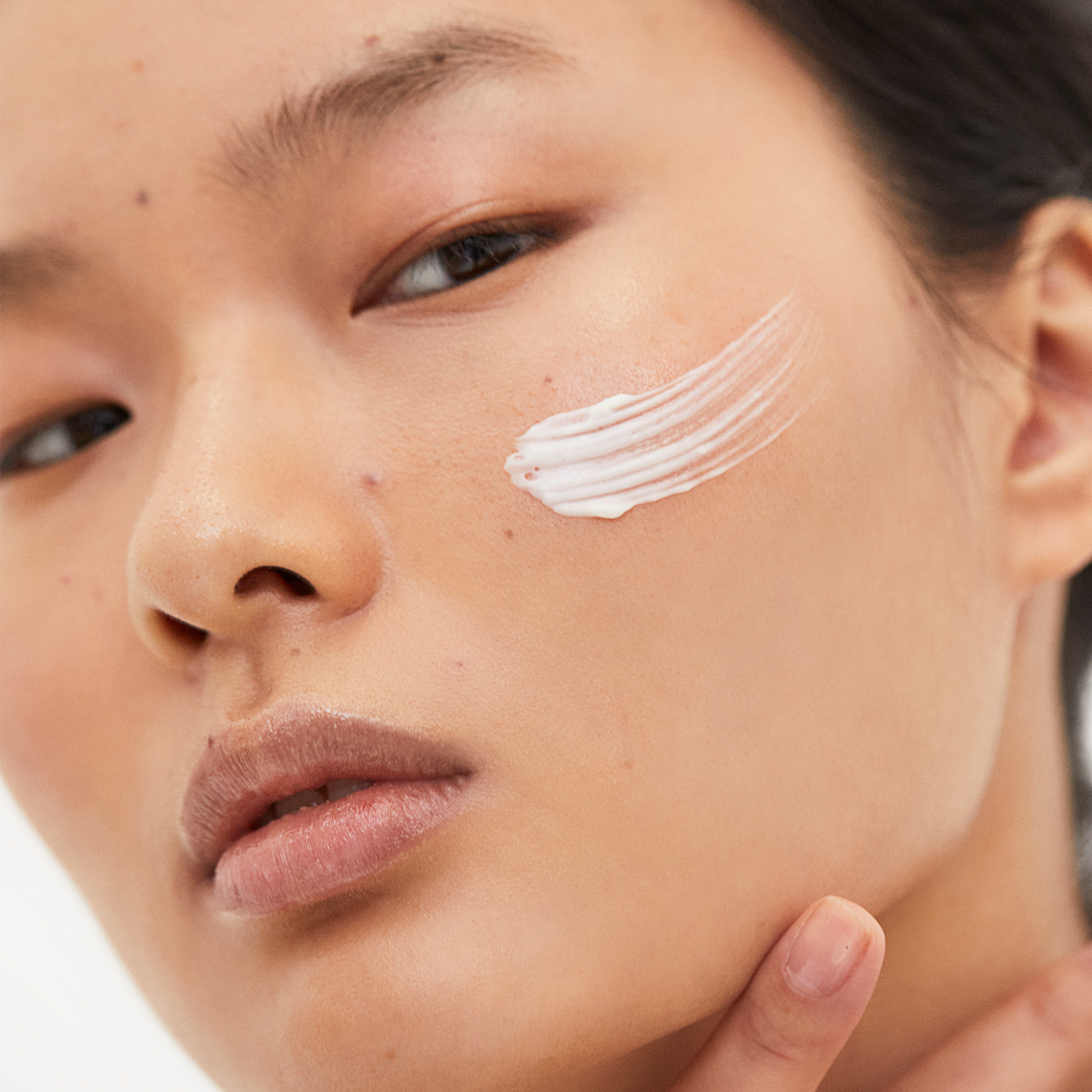 Close up shot of women with Unique CBD body cream on her face